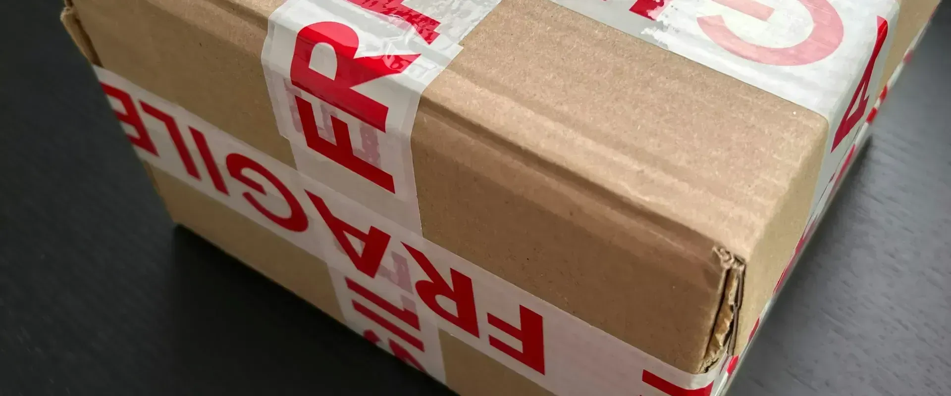 Cardboard package wrapped with fragile tape